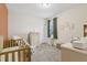 Bright bedroom with a crib, dresser, and window with green curtains at 440 Pierce Landing Dr, Garner, NC 27529