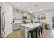 Modern kitchen boasts gray cabinets, quartz countertops, stainless steel appliances, island with seating, and a window at 440 Pierce Landing Dr, Garner, NC 27529
