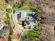An aerial view of the estate, features a gray roof, a private pool, and well-manicured landscaping with brick accents at 4405 Turnberry Cir, Durham, NC 27712
