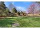 A well-manicured backyard featuring vibrant greenery, tiered landscaping, and blooming pink trees at 4405 Turnberry Cir, Durham, NC 27712