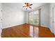 Light-filled bedroom with hardwood floors, ceiling fan, and large windows at 4405 Turnberry Cir, Durham, NC 27712