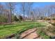 Spacious front yard features lush green grass, mature trees, and a brick pathway leading to the home at 4405 Turnberry Cir, Durham, NC 27712