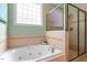 Bright bathroom featuring a soaking tub with jets and a glass-enclosed shower at 4773 Swordfish Dr, Raleigh, NC 27603