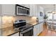 Modern kitchen featuring stainless steel appliances, granite countertops, and white cabinetry at 4773 Swordfish Dr, Raleigh, NC 27603