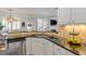 Well-appointed kitchen featuring an island, stainless steel dishwasher, and granite counters with view to living room at 4773 Swordfish Dr, Raleigh, NC 27603