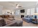 Spacious living room featuring a fireplace, ceiling fan, and abundant natural light through large windows at 4773 Swordfish Dr, Raleigh, NC 27603