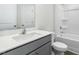 Bright bathroom featuring a single sink vanity with gray cabinets and a tub with a shower at 50 Sweet Meadow Rd, Angier, NC 27501