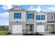 This townhouse features an attached one-car garage with a stone-accented base at 50 Sweet Meadow Rd, Angier, NC 27501