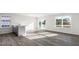 Sunlit living room with gray flooring, a wet bar, and a sliding glass door to the outdoors at 50 Sweet Meadow Rd, Angier, NC 27501