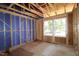 Exposed framing, blue sheathing, and windows are featured in this customizable unfinished room at 6966 Doddridge Ln # 12, Cary, NC 27519