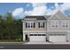 New townhome exterior showcasing stylish design, neutral colors, and attached garages with green lawns at 6968 Doddridge Ln # 11, Cary, NC 27519