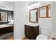 Clean bathroom with a dark wood vanity, mirror, and bright lighting at 7205 Sandy Creek Dr, Raleigh, NC 27615
