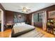 Bedroom with a cozy bed, wood accent wall, and natural light streaming through the window at 7205 Sandy Creek Dr, Raleigh, NC 27615