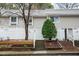 Inviting townhouse exterior with lush landscaping and a bright white fence at 7205 Sandy Creek Dr, Raleigh, NC 27615