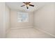 Clean and bright bedroom with neutral walls, ceiling fan, and a large window at 7213 Terregles Dr, Raleigh, NC 27617