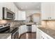Modern kitchen featuring stainless appliances, granite countertops, and white cabinetry at 7213 Terregles Dr, Raleigh, NC 27617