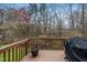 Wooden deck with railings overlooking a wooded backyard and a grill with cover at 7753 Winners Edge St, Raleigh, NC 27617