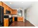 Well-lit kitchen featuring wood cabinets, black appliances, and hardwood floors at 7753 Winners Edge St, Raleigh, NC 27617