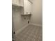 Laundry room offers overhead cabinets and a unique gray and white patterned tile floor at 9000 Penny Rd, Raleigh, NC 27606