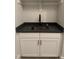Close up of white cabinets with a dark countertop and a stainless sink with black faucet at 9000 Penny Rd, Raleigh, NC 27606
