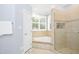 Well-lit bathroom features a large shower, soaking tub, and tile flooring at 9700 Pentland Ct, Raleigh, NC 27614