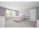 Bright bedroom featuring a large window, custom light fixture, and soft neutral color scheme at 9700 Pentland Ct, Raleigh, NC 27614