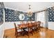 Formal dining room with hardwood floors, elegant chandelier, and designer wallpaper at 9700 Pentland Ct, Raleigh, NC 27614