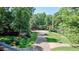 Long driveway leading to a secluded home surrounded by mature trees and landscaping at 9700 Pentland Ct, Raleigh, NC 27614