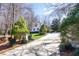 View of long driveway leading up to a white house with well-maintained landscaping and mature trees at 9700 Pentland Ct, Raleigh, NC 27614