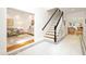 Bright foyer featuring a staircase with dark railings, tile flooring, and views into the living spaces at 9700 Pentland Ct, Raleigh, NC 27614
