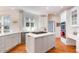 Well-lit kitchen featuring white cabinets, marble countertops, stainless appliances, and central island with gas cooktop at 9700 Pentland Ct, Raleigh, NC 27614