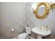 Stylish powder room features patterned wallpaper and gold mirror and fixtures at 9700 Pentland Ct, Raleigh, NC 27614