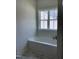 Bathroom showcasing a white tub and window, accented by stylish flooring at 1039 N Lincoln St, Benson, NC 27504