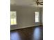 Bedroom featuring hardwood floors, two large windows, and ceiling fan at 1039 N Lincoln St, Benson, NC 27504