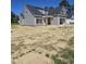 New two-story home with gray siding, covered front porch and attached garage at 1039 N Lincoln St, Benson, NC 27504