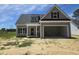 New gray home featuring a large two car garage, black shutters and a covered front porch at 1039 N Lincoln St, Benson, NC 27504