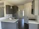 Well-lit kitchen with stainless steel sink, gray cabinets, and white countertops at 1039 N Lincoln St, Benson, NC 27504