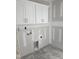 View of the laundry room with white upper cabinets and utility connections at 1039 N Lincoln St, Benson, NC 27504