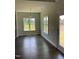 Bright living area with hardwood floors, two large windows, and a glass door at 1039 N Lincoln St, Benson, NC 27504