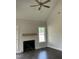 Bright living room featuring a fireplace, wood floors, a ceiling fan and a large window at 1039 N Lincoln St, Benson, NC 27504