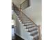 Elegant staircase featuring light wood treads, white risers, and wrought iron balusters at 1039 N Lincoln St, Benson, NC 27504