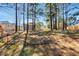 Spacious wooded backyard featuring a glimpse of the home, perfect for outdoor activities at 105 Byron Ct, Oxford, NC 27565