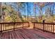 A stained deck overlooking wooded backyard with mature trees and blue skies at 105 Byron Ct, Oxford, NC 27565