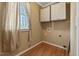 Bright laundry area with hardwood floors, window, and plenty of overhead cabinet storage at 105 Byron Ct, Oxford, NC 27565