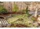 Backyard with lush garden and landscaped areas leads to a bridge, creating a serene outdoor experience at 10729 Trego Trl, Raleigh, NC 27614