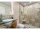 Sleek bathroom featuring a modern vanity with a glass countertop and a glass-enclosed shower at 10729 Trego Trl, Raleigh, NC 27614