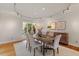 Dining room with hardwood floors, neutral paint, a large window, and six chairs around the dining table at 10729 Trego Trl, Raleigh, NC 27614