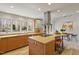 Modern kitchen featuring an island, stainless steel range hood, wooden cabinets, and scenic backyard views at 10729 Trego Trl, Raleigh, NC 27614