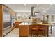 Updated kitchen featuring stainless steel appliances, an island with bar seating, and large windows offering natural light at 10729 Trego Trl, Raleigh, NC 27614