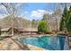 A backyard pool and patio offers relaxation and entertainment surrounded by mature trees and landscaping at 10729 Trego Trl, Raleigh, NC 27614